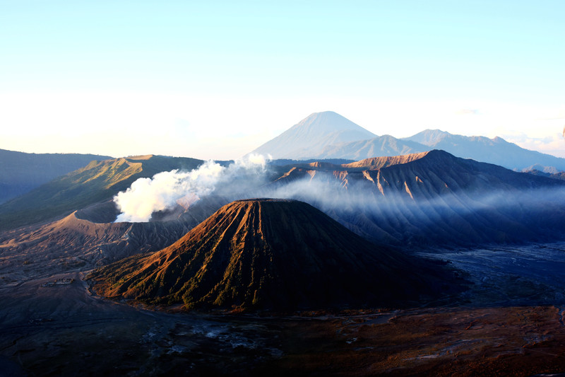 广袤的荒原上透露着一片荒凉,一前一后两座圆锥形的火山一高一矮形成